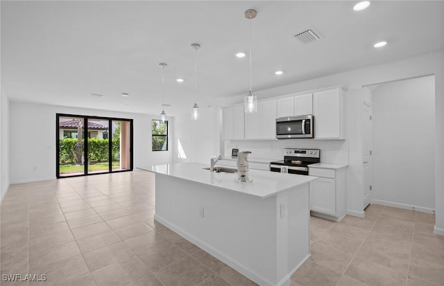 kitchen with white cabinetry, stainless steel appliances, hanging light fixtures, and a center island with sink