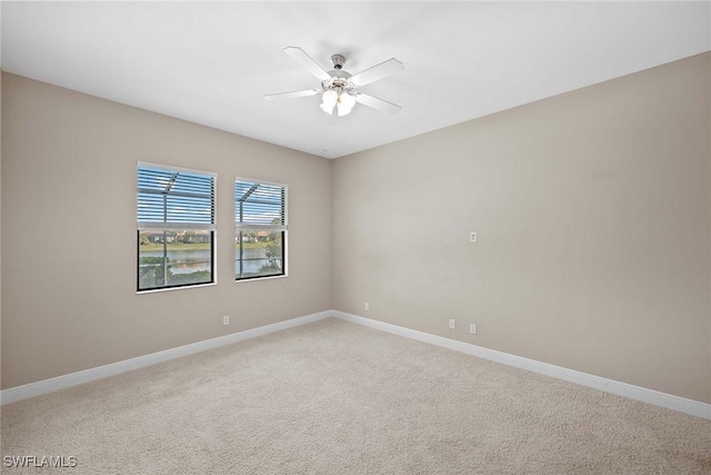 empty room featuring light carpet, ceiling fan, and baseboards