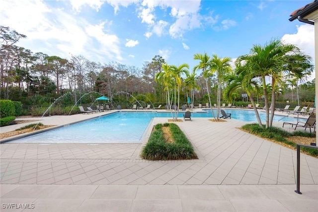 community pool with a patio and fence