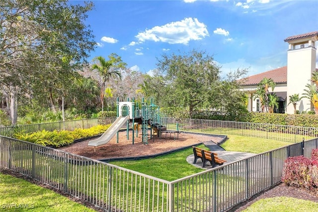 community jungle gym with fence and a lawn