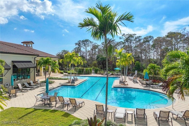 community pool featuring fence and a patio