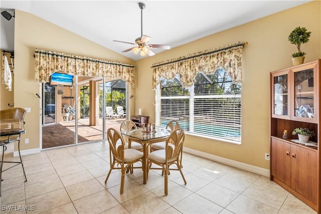 tiled dining area featuring ceiling fan and lofted ceiling