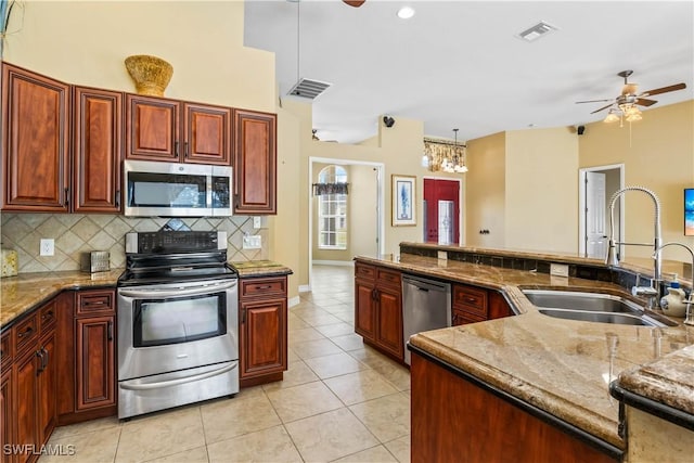 kitchen with sink, hanging light fixtures, ceiling fan, stainless steel appliances, and backsplash