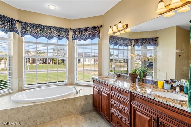 bathroom with vanity, a relaxing tiled tub, and tile patterned floors