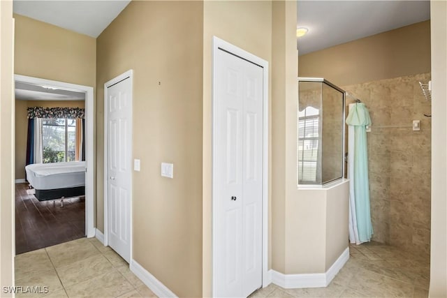 bathroom with a tile shower and tile patterned floors