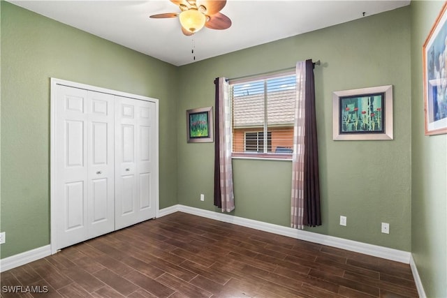 unfurnished bedroom with dark wood-type flooring, ceiling fan, and a closet