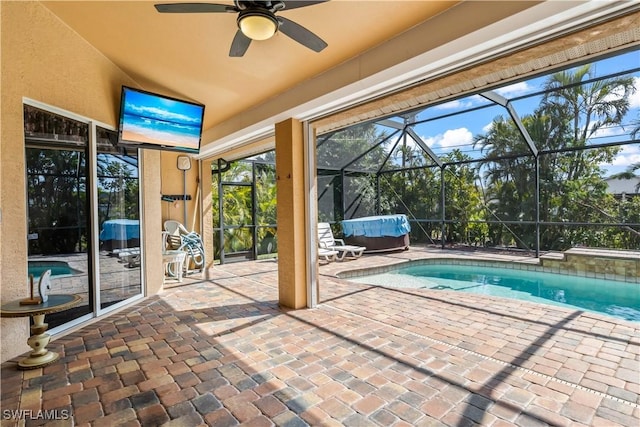 view of swimming pool with a patio area, a hot tub, ceiling fan, and glass enclosure