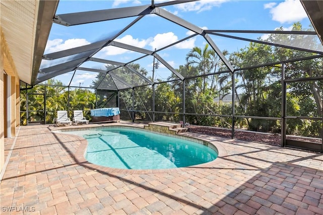 view of pool with a patio and glass enclosure