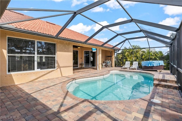 view of pool with ceiling fan, a patio, and glass enclosure