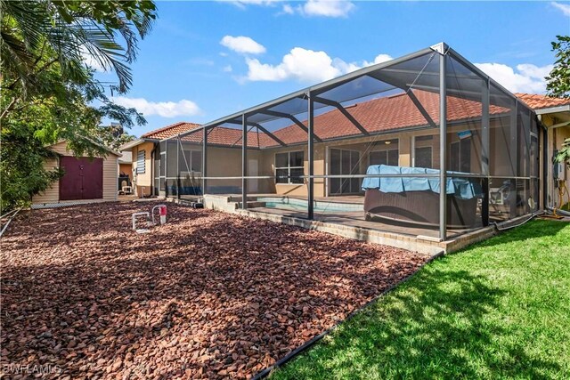 back of property with a storage shed, a lanai, and a patio area