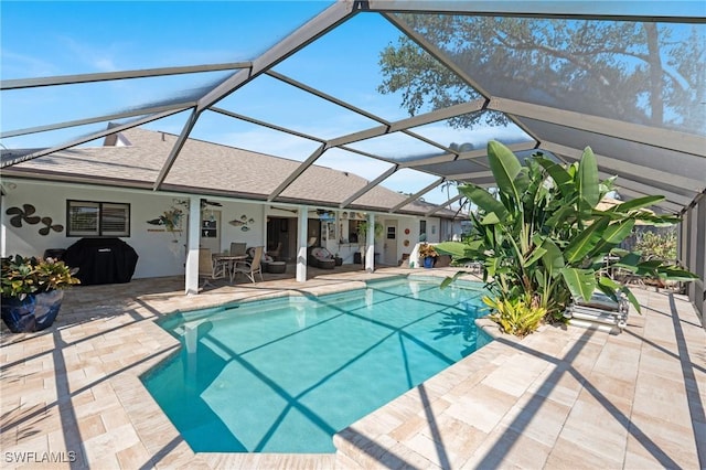 view of pool with a patio and glass enclosure