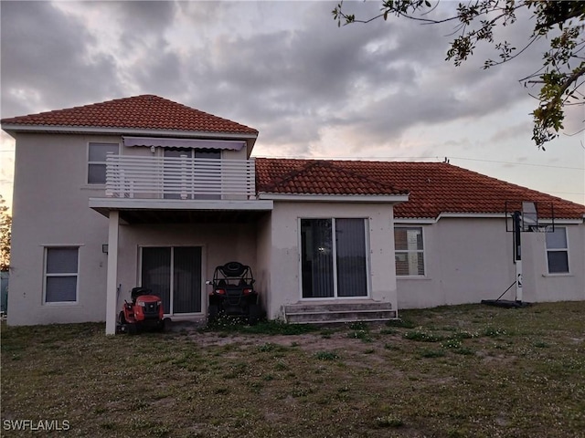 rear view of property featuring a lawn