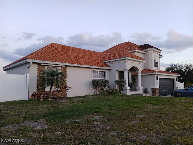 mediterranean / spanish home with a garage and a front yard