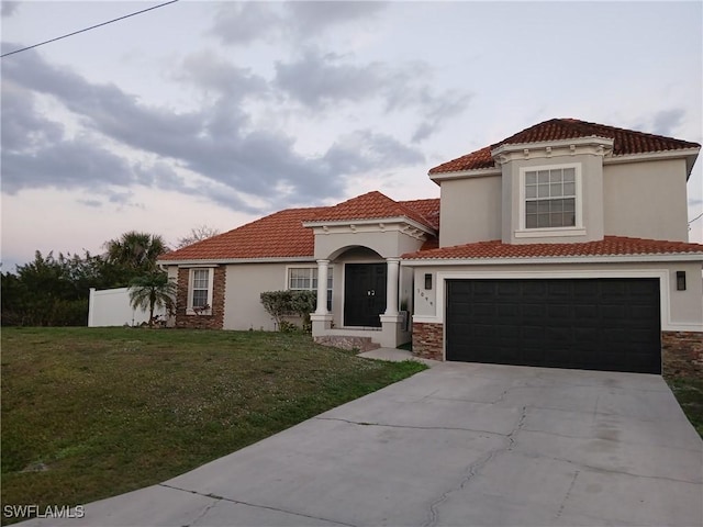 mediterranean / spanish-style home with a garage and a front lawn