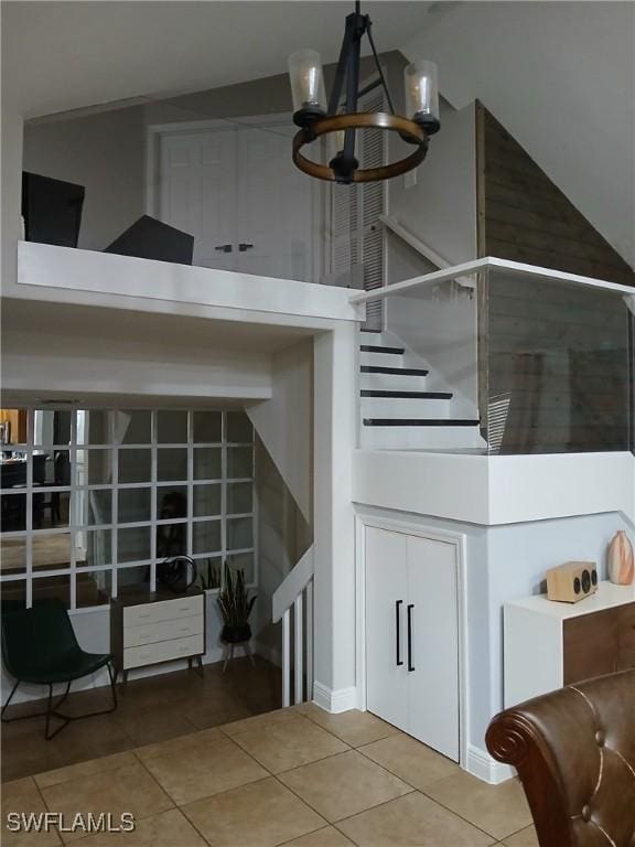 stairway featuring tile patterned flooring and a notable chandelier