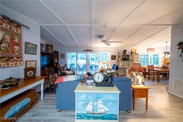 living room featuring vaulted ceiling, light hardwood / wood-style floors, and ceiling fan