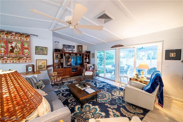 living room featuring hardwood / wood-style flooring, ceiling fan, and lofted ceiling with beams