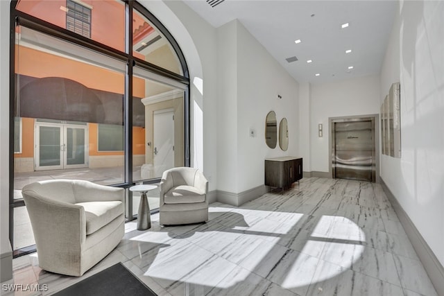 interior space with elevator and french doors