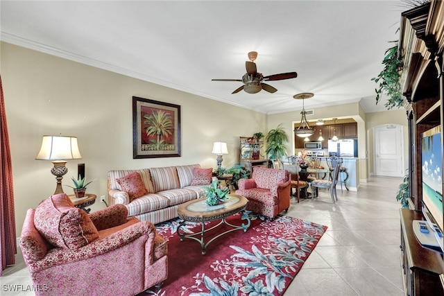 living room featuring light tile patterned floors, crown molding, and ceiling fan