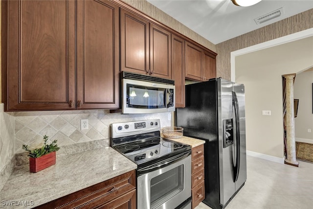 kitchen featuring light stone counters, tasteful backsplash, decorative columns, and appliances with stainless steel finishes