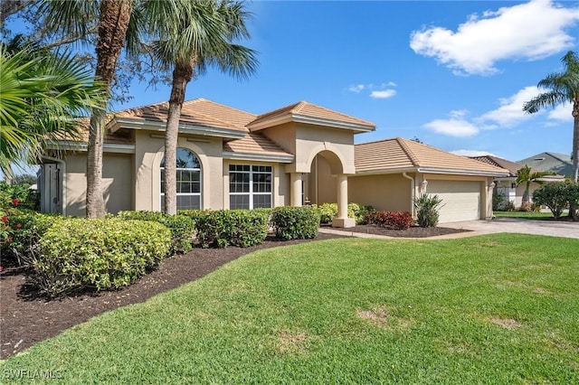 mediterranean / spanish-style house featuring concrete driveway, an attached garage, a front lawn, and stucco siding