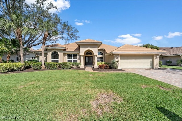 mediterranean / spanish-style home featuring a garage and a front yard