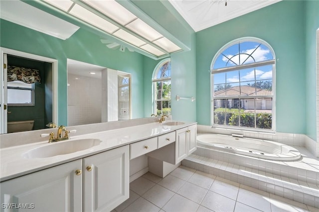 bathroom featuring tile patterned flooring, vanity, ornamental molding, a relaxing tiled tub, and toilet