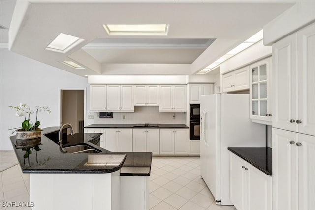 kitchen featuring white cabinetry, a tray ceiling, sink, and black appliances