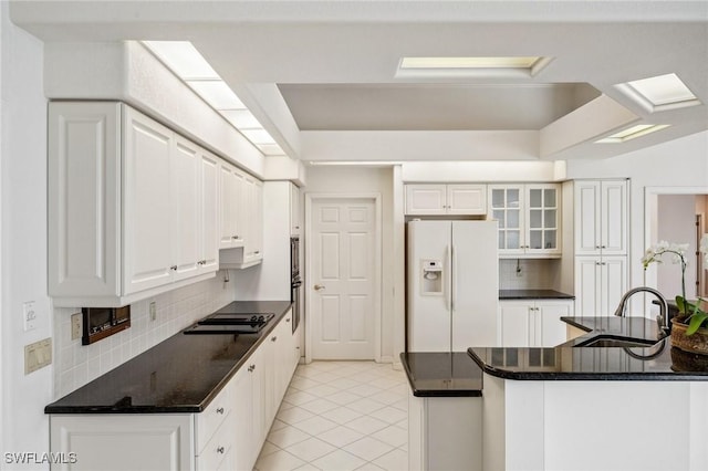 kitchen featuring tasteful backsplash, sink, white refrigerator with ice dispenser, and white cabinets