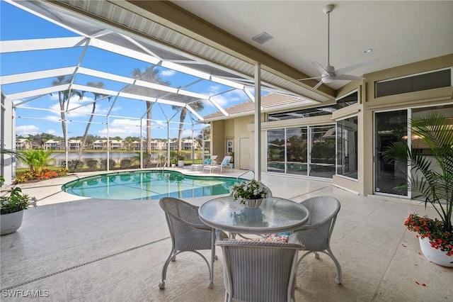 view of pool featuring a patio area, a water view, ceiling fan, and glass enclosure