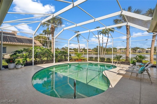 view of pool with a patio, a water view, and glass enclosure