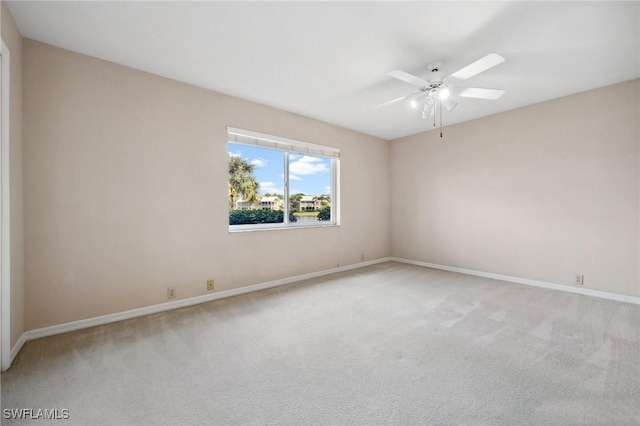 spare room featuring ceiling fan, baseboards, and light colored carpet