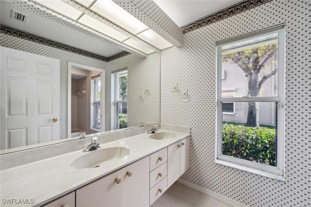 bathroom with vanity, tile patterned flooring, a shower, and a wealth of natural light