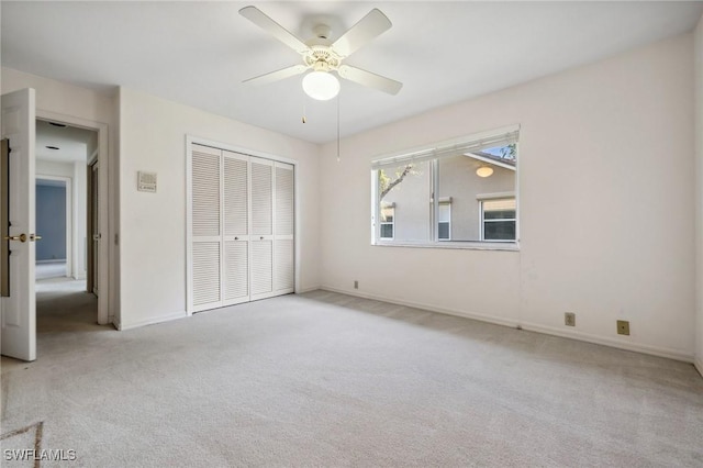 unfurnished bedroom with light colored carpet, a closet, and ceiling fan