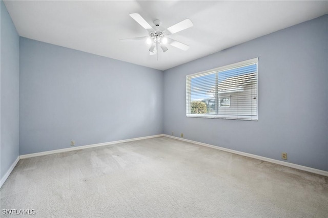 spare room featuring carpet floors, ceiling fan, and baseboards