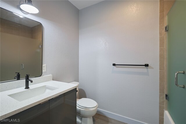 bathroom featuring vanity, hardwood / wood-style flooring, toilet, and walk in shower