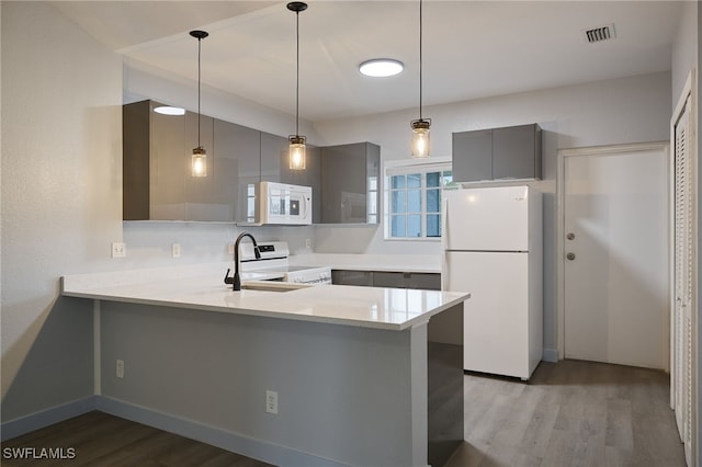 kitchen featuring white appliances, light hardwood / wood-style flooring, gray cabinets, hanging light fixtures, and kitchen peninsula