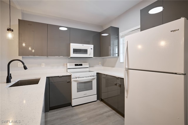 kitchen with pendant lighting, sink, gray cabinetry, light stone counters, and white appliances