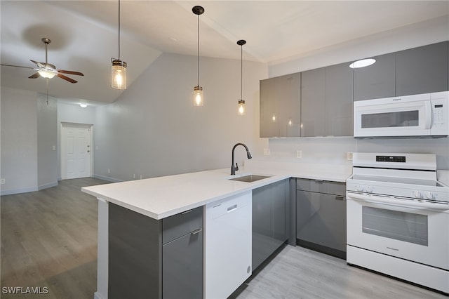 kitchen featuring sink, gray cabinetry, hanging light fixtures, kitchen peninsula, and white appliances