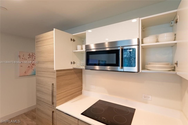 kitchen featuring black electric cooktop and hardwood / wood-style flooring