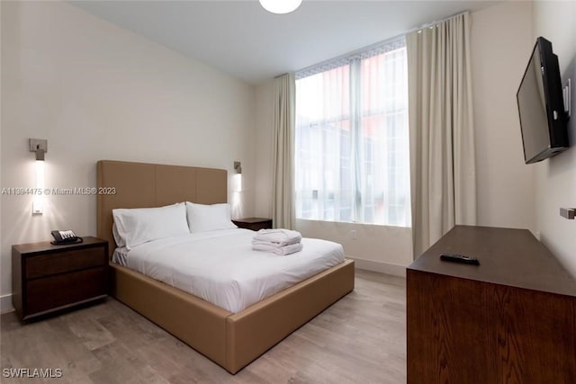 bedroom with multiple windows and light hardwood / wood-style floors