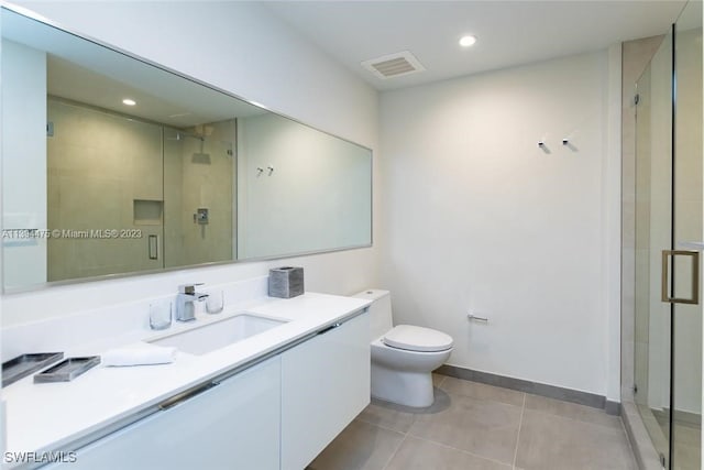 bathroom with walk in shower, vanity, tile patterned floors, and toilet