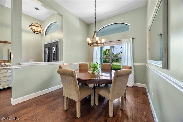 dining space with a towering ceiling, dark hardwood / wood-style floors, and a chandelier