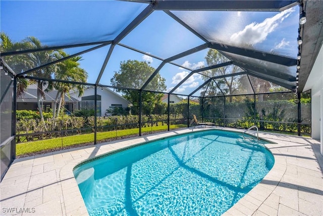 view of pool with a patio and glass enclosure