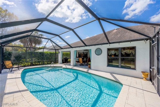 view of swimming pool featuring glass enclosure and a patio area