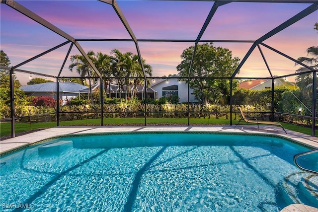 pool at dusk featuring a lanai