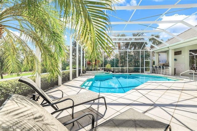 pool featuring glass enclosure and a patio area