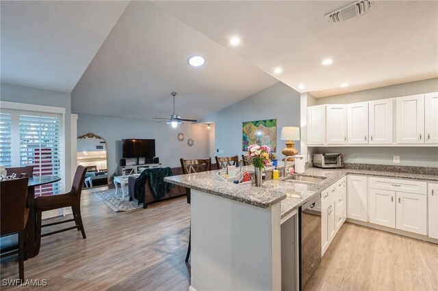 kitchen featuring sink, black dishwasher, kitchen peninsula, and white cabinets