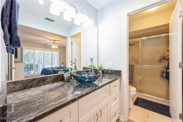 bathroom featuring ceiling fan, tile patterned flooring, vanity, toilet, and walk in shower