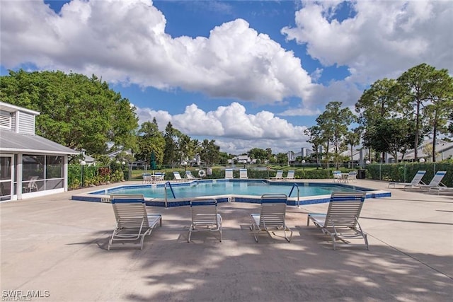 view of pool featuring a sunroom, a jacuzzi, and a patio